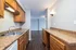Elegant kitchen with granite countertops, modern wood cabinetry, and a sleek, open layout leading to a bright living area.
