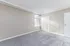 Bright and spacious bedroom featuring plush carpet, neutral walls, and a large window for natural light.