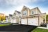 Charming townhouse exterior with modern design, featuring attached garages and well-kept landscaping in a serene neighborhood setting.