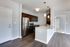 Modern kitchen with stainless steel appliances, sleek dark cabinets, and stylish pendant lighting in a contemporary apartment.