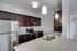 Modern kitchen with sleek stainless steel appliances, elegant dark wood cabinetry, and a stylish island with pendant lighting.