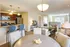 Bright and inviting open-concept apartment featuring a modern kitchen with stainless steel appliances, cozy living area, and elegant dining space.