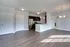 Elegant open-concept living space with stylish modern kitchen, featuring stainless steel appliances and sleek wood flooring.