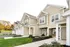 Charming townhouse exterior with elegant siding, modern garage doors, and landscaped front gardens under a clear sky.