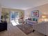 Bright and spacious living room with modern furniture, large sliding glass door, and private balcony at Haynes Run Apartments in Medford, NJ