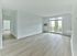 Spacious living room with wood-style flooring and private balcony at Crestwood Apartments in Wayne, PA