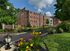 Wide view of Crestwood Apartments with colorful gardens, main entry sign, and classic brick architecture in Wayne, PA