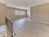 Open-concept living room with light wood-style flooring, neutral walls, and ceiling fan at Maple Grand Apartments in Maple Shade, New Jersey.