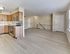 Updated kitchen with stainless steel appliances, wood-style cabinetry, and open living space at Maple Grand Apartments in Maple Shade, New Jersey.