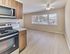 Updated kitchen with stainless steel appliances and spacious dining area with large windows at Maple Grand Apartments in Maple Shade, New Jersey.