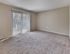 Spacious carpeted bedroom with sliding glass door to private patio at Maple Grand Apartments in Maple Shade, New Jersey.
