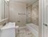 Renovated bathroom with large vanity, modern tile surround, and ceramic flooring at Maple Grand Apartments in Maple Shade, New Jersey.