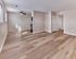 Spacious open-concept living and dining area with wood-style flooring at Village Square Apartments.