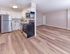 Renovated kitchen with stainless steel appliances and open living area at Village Square Apartments.