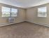 Carpeted bedroom with natural light and neutral walls at Audubon Arms Apartments.