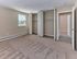 Large carpeted bedroom with double closets and natural light at Audubon Arms Apartments.