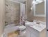Renovated bathroom with tiled shower, modern vanity, and brushed nickel fixtures at Audubon Arms Apartments in Audubon, NJ