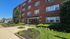 Exterior view of Audubon Arms Apartments with well-maintained landscaping and red brick facade in Audubon, NJ
