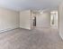 Open-concept living area with plush carpet and view of kitchen and bathroom at 42 West Apartments in Merchantville, NJ