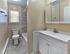 Updated bathroom with modern vanity, mirrored cabinet, and tiled shower at 42 West Apartments in Merchantville, NJ
