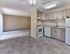 Modern kitchen with wood-tone cabinetry and open layout to living room at Maple Terrace Apartments in Maple Shade, NJ