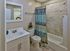 Updated bathroom with modern vanity, tiled shower, and decorative accents at Haynes Run Apartments in Medford, NJ