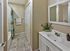 Modern bathroom with tiled flooring, vanity with mirror, and shower at Haynes Run Apartments in Medford, NJ