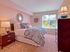 Bright and spacious bedroom with carpeted flooring, and large window at Haynes Run Apartments in Medford, NJ