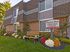 Leasing office sign and entrance at Haynes Run Apartments in Medford, NJ with flowers and bench in front