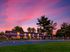 Twilight view of building 1200 at Haynes Run Apartments in Medford, NJ with illuminated windows, parking lot, and playground