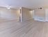 Bright and spacious living room with light wood-style flooring, ceiling fan, and neutral walls at Maple Grand Apartments in Maple Shade, New Jersey.