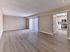 Open-concept living room with wood-style flooring and modern kitchen in a 2 bedroom, 2 bathroom apartment at North Crossing.