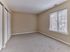 Carpeted secondary bedroom with large window and closet in a 2 bedroom, 2 bathroom apartment at North Crossing in Willow Grove, PA.