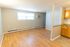 spacious open room with wood floor and high window