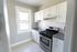 modern kitchen with stove, with cabinets, window, and tiled backsplash