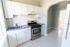 modern kitchen with stove, fridge, with white cabinets, window, and tiled backsplash