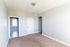 carpeted room with doorway to kitchen and arched doorway