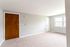 carpeted front room with large windows