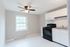 modern kitchen with window, stove, vinyl floor, cabinets and ceiling fan