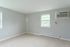 carpeted corner with two windows and A/C