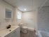 renovated bathroom, white with tile shower and vanity with cabinets