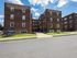 folcroft courts apartments street view, tall brick buildings, blue apartment sign, concrete walkways through green grass