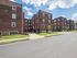 folcroft courts apartments street view, tall brick buildings, blue apartment sign, concrete walkways through green grass