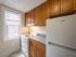 kitchen with wooden cabinets and white fridge and oven/stove, apartment kitchen with window