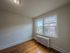 apartment bedroom looking out large windows, radiator and overhead light