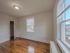 apartment bedroom looking out large windows, radiator and overhead light