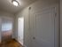 apartment hallway with overhead light, view past closet and bathroom to bedroom