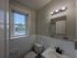 bathroom with vanity, modern accents and energy efficient toilet, window