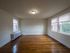 large bedroom with lots of windows, hardwood floor, overhead light, radiator
