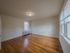 large bedroom with lots of windows, hardwood floor, overhead light, radiator